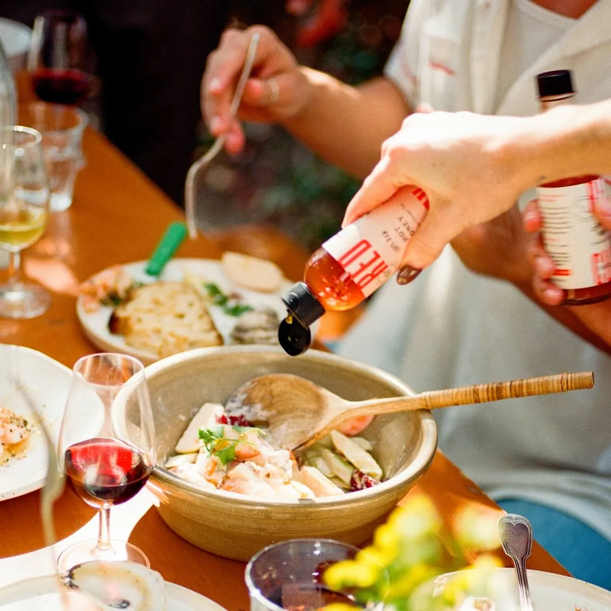 Hot honey poured over a bowl at a dinner table
