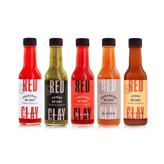 Five Red Clay hot sauce bottles in a row